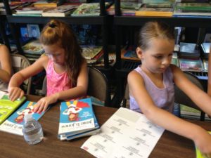 Nava Berezin, age 6 and Lila Marchese, age 5, volunteer at Link to Libraries in Hampden, Massachusetts. (Nancy Eve Cohen for NEPR)