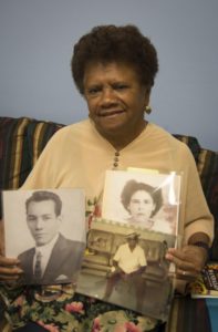 Julita Rojas holds up family photos that she shared with the Holyoke Public Library's new archive project. The project, "Nuestros Senderos: Our Journeys and Our Lives in Holyoke," aims to gather information about Holyoke's Puerto Rican communities.