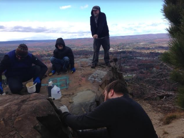 A group of people spent the day scrubbing rocks on Mt. Tom to erase racist and anti-Semitic graffiti. (Nancy Eve Cohen)
